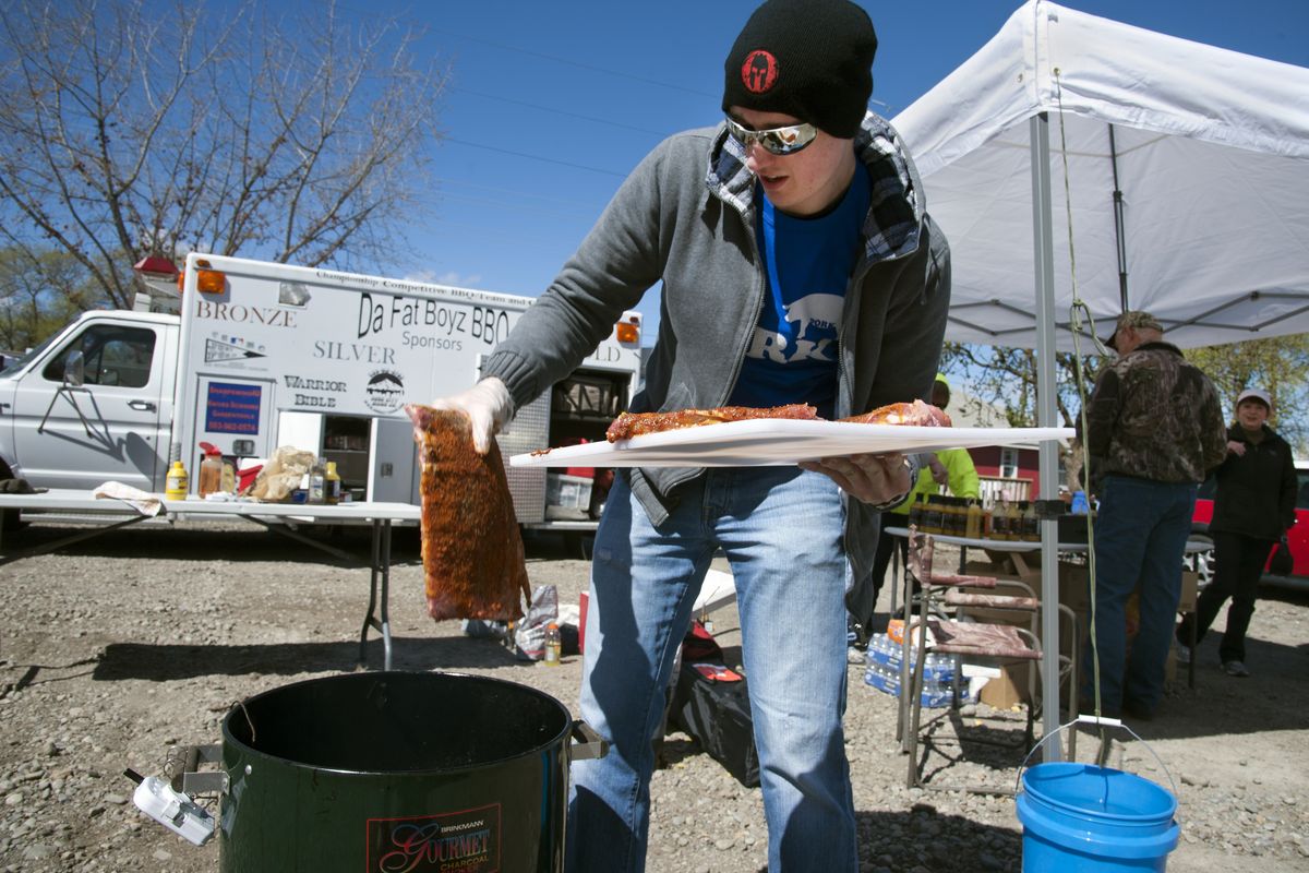 Tino Morenz slaps ribs on the grill Saturday as he participates in the Smoke in the Valley BBQ Championship at Uncle LeRoy’s BBQ on Pines Road in Spokane Valley. Morenz will be a judge today when the main competitors vie for cash prizes totaling $5,000. Morenz says his secret to successful ribs is “Don’t burn it.” (Dan Pelle)