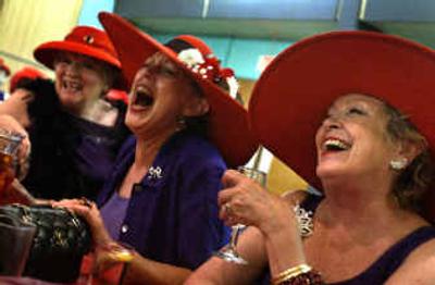 
Kathryn Smith, right, and Carol Allen, center, share a laugh with other Red Hatters as they reminisce about past experiences during  a gathering Saturday at the Eagles Club. 