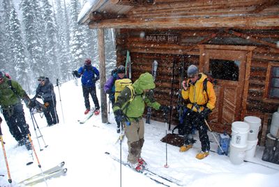 Mark Yancey, right, listens to a radio weather report before leading skiers from the remote Boulder Hut to backcountry skiing areas high in the Purcell Mountains northwest of Kimberley, British Columbia.   (Rich Landers / The Spokesman-Review)