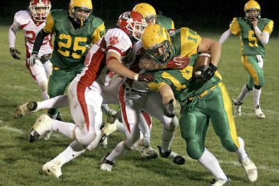 
Lakeland's Bubba Bartlett (14) is dragged down by Sandpoint defenders after a short gain. He scored the Hawks' second touchdown.
 (Bruce Twitchell / The Spokesman-Review)