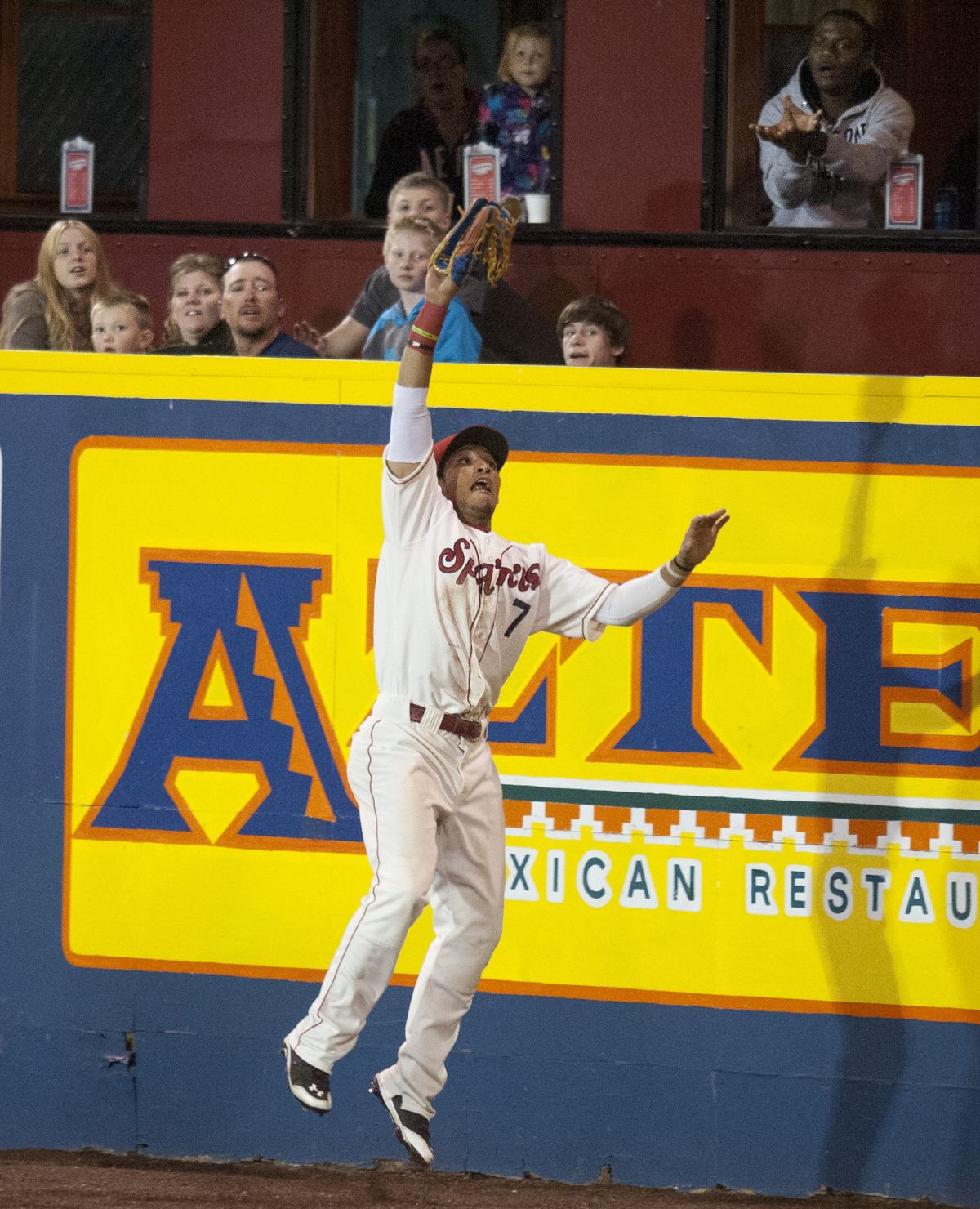 Spokane’s Diego Cedeno makes leaping catch in front of the right-field fence Thursday night. (Tyler Tjomsland)