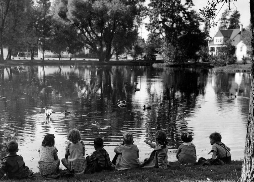 Indian summer has touched its magic wand to Manito park, clothing the ground, trees and shrubs in a riot of fall colors. Taking in the beauty of the scene and visiting the wild ducks on the park pond are visitors from the Lincoln child care center. Oct. 17, 1943.  (Photo Archive/spokesman-review)