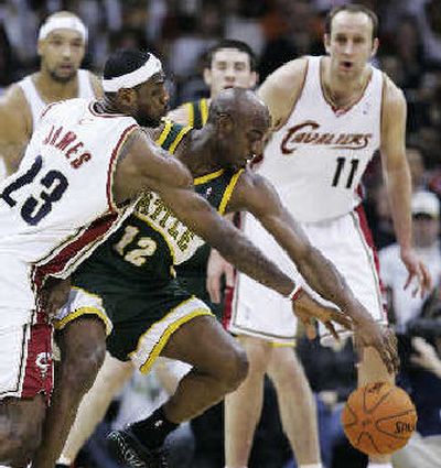 
Cavaliers' LeBron James, left, and Sonics' Damien Wilkins scramble for loose ball. 
 (Associated Press / The Spokesman-Review)