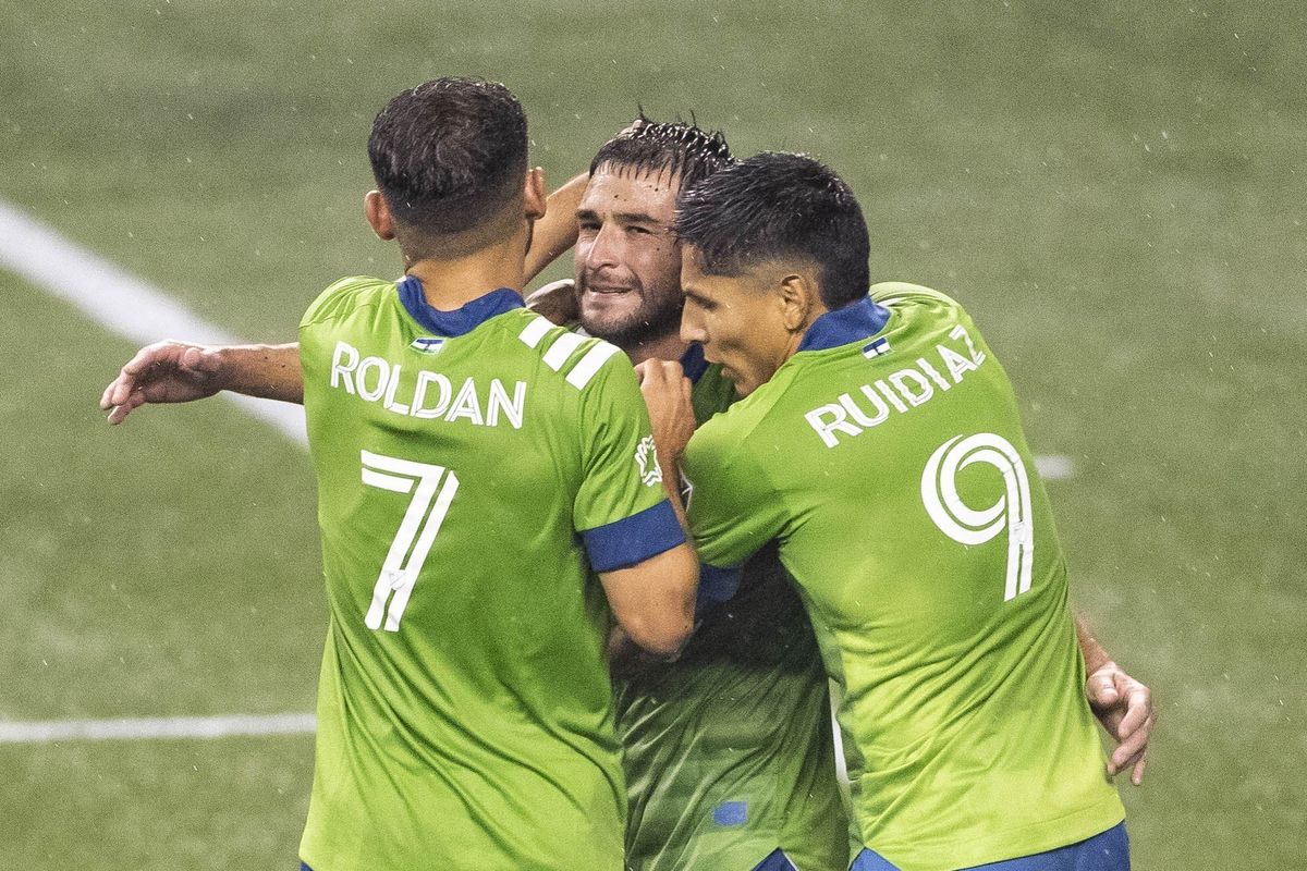 Seattle Sounders gather around captain Nicolas Lodeiro, center, after he scored the second of two penalty kicks in the first half of an MLS soccer match against Los Angeles FC, Friday, Sept. 18, 2020, in Seattle.  (Associated Press)