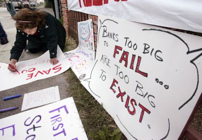 A woman makes signs during an antiforeclosure rally Thursday in Oakland, Calif. Some of the nation’s largest banks will be scrambling to demonstrate that they can raise capital after results of government stress tests showed many need more capital.  (Associated Press / The Spokesman-Review)