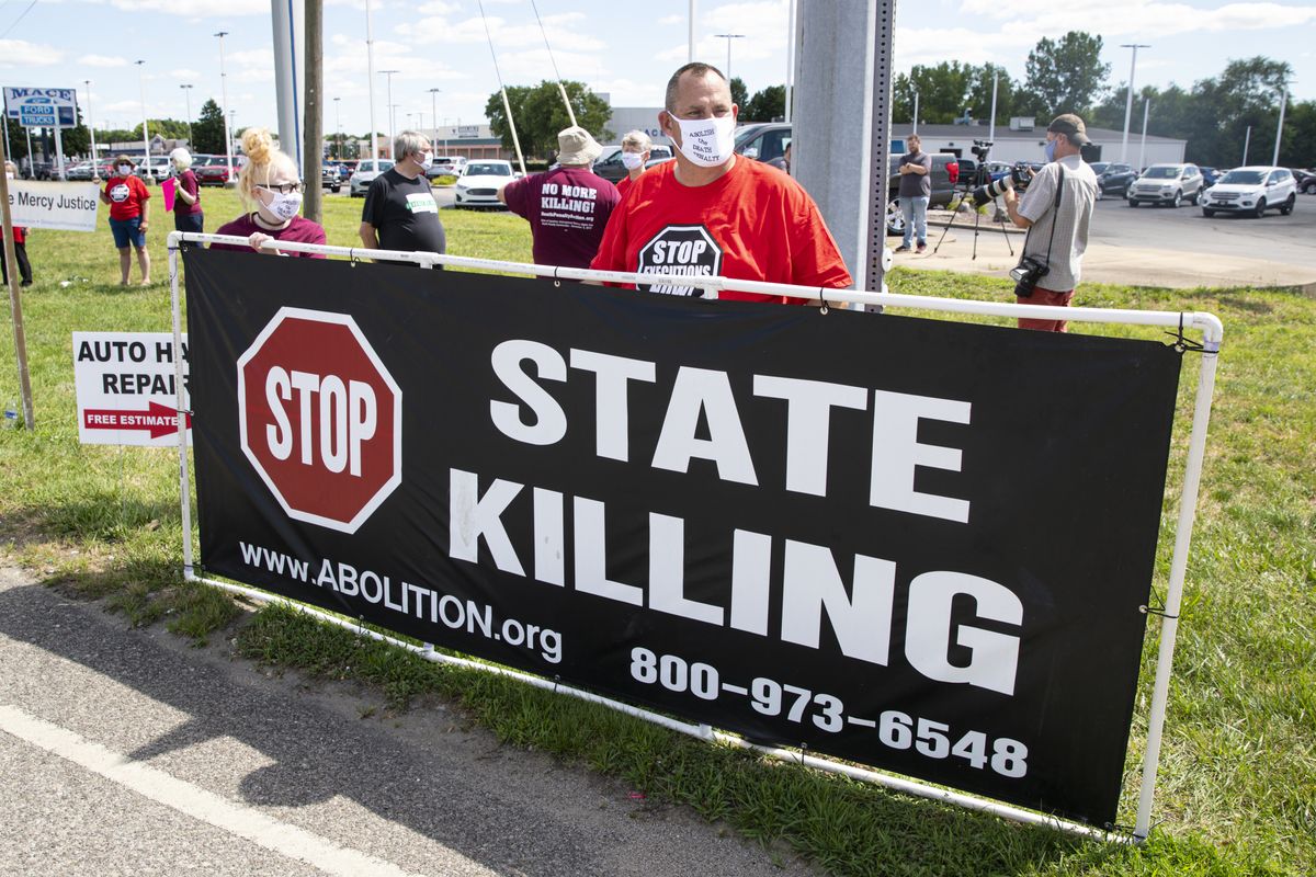 Protesters against the death penalty gather in Terre Haute, Ind., Monday, July 13, 2020. Daniel Lewis Lee, a convicted killer, was scheduled to be executed at 4 p.m. in the federal prison in Terre Haute. He was convicted in Arkansas of the 1996 killings of gun dealer William Mueller, his wife, Nancy, and her 8-year-old daughter, Sarah Powell.  (Michael Conroy)