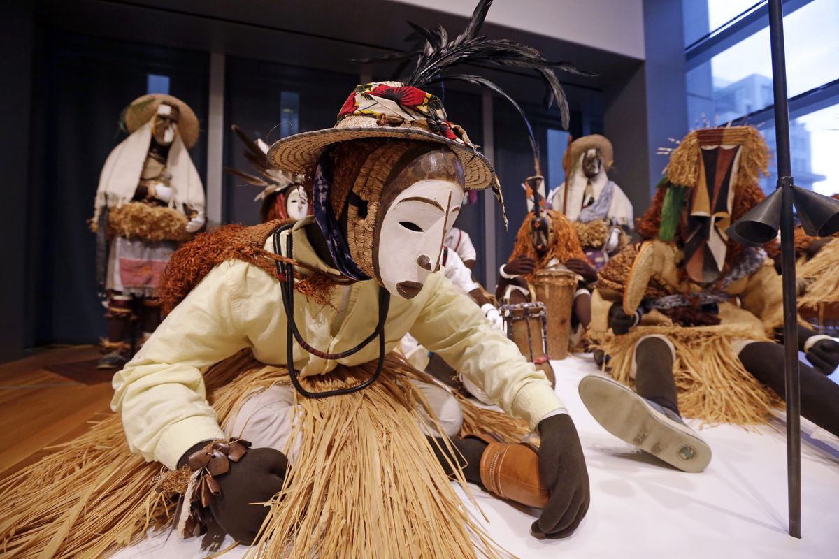 Nigerian masks from the 1950s are displayed with costumes at the “Disguise” exhibit at the Seattle Art Museum. (Associated Press)