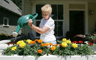 
Joan Voves, the first resident at Danielson Grove, an innovative housing demonstration project, in Kirkland, Wash., waters her flowers earlier this month
 (The Spokesman-Review)