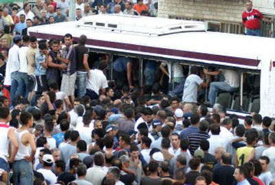 
A crowd surrounds a bus where a Jewish extremist opened fire, killing four people, in the Israeli town of Shfaram on Thursday. 
 (Associated Press / The Spokesman-Review)