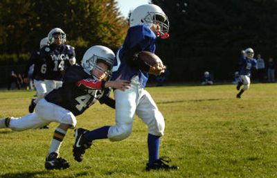 
During a game of YMCA Grid Kids tackle football at Evergreen Middle School, third-grader Chase Binder, left, of the Central Valley No. 2 Bears tackles Gage Felix, also a third-grader, with the University No. 2 Angry Midgets.
 (Holly Pickett photos / The Spokesman-Review)