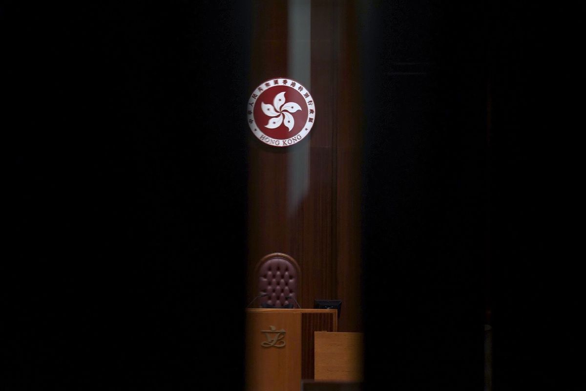 The logo of Hong Kong Special Administrative Region is seen through the glass of a closed door after the first and second meeting of "Improving Electoral System (Consolidated Amendments) Bill 2021" finished at the Legislative Council in Hong Kong Wednesday, April 14, 2021. Hong Kong’s electoral reform bill was introduced in the city’s legislature on Wednesday, setting in motion changes that will give Beijing greater control over the process while reducing the number of directly elected representatives.  (Vincent Yu)