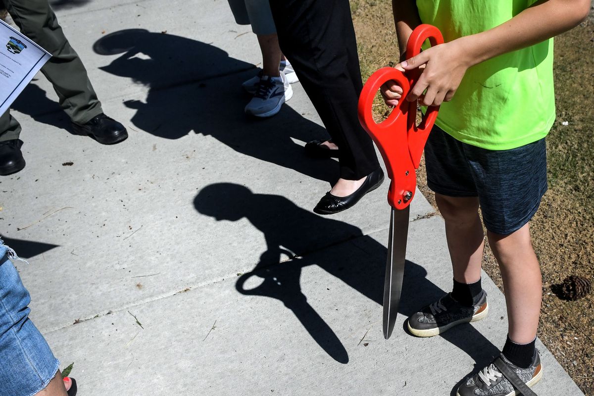 Emmett Yarbrough, 6, holds giant scissors for his mom, Lori, Athol’s City Clerk/Treasurer, before a ribbon-cutting in honor of the first sidewalk in Athol.  (Kathy Plonka/The Spokesman-Review)