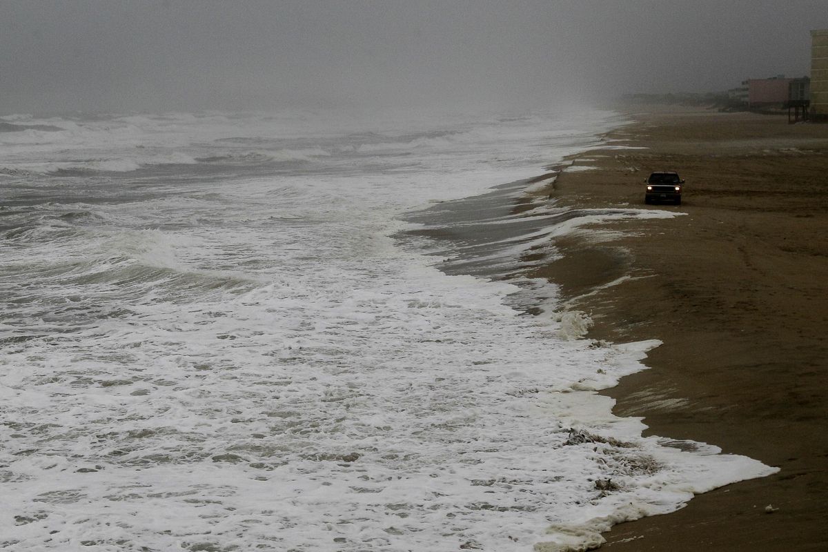 A vehicle drives along the beach as waves generated by Hurricane Sandy crash ashore in Nags Head, N.C., Saturday, Oct. 27, 2012. Hurricane Sandy, upgraded again Saturday just hours after forecasters said it had weakened to a tropical storm, was barreling north from the Caribbean and was expected to make landfall early Tuesday near the Delaware coast, then hit two winter weather systems as it moves inland, creating a hybrid monster storm. (Gerry Broome / Associated Press)