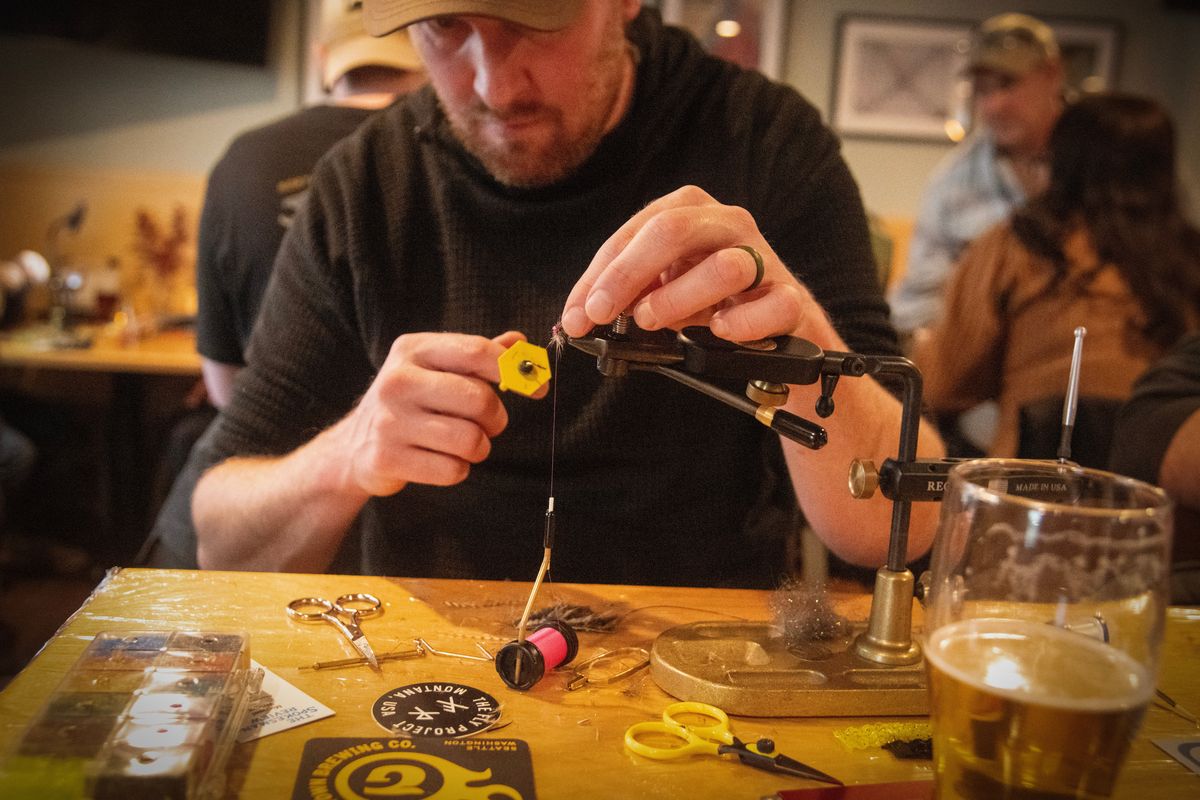 Chris Mowry, who won the contest, works on his entry in the fly tying contest at the Radio Bar Sunday, Feb. 22, 2026. Mowry won the contest.   (Michael Wright/The Spokesman-Review)