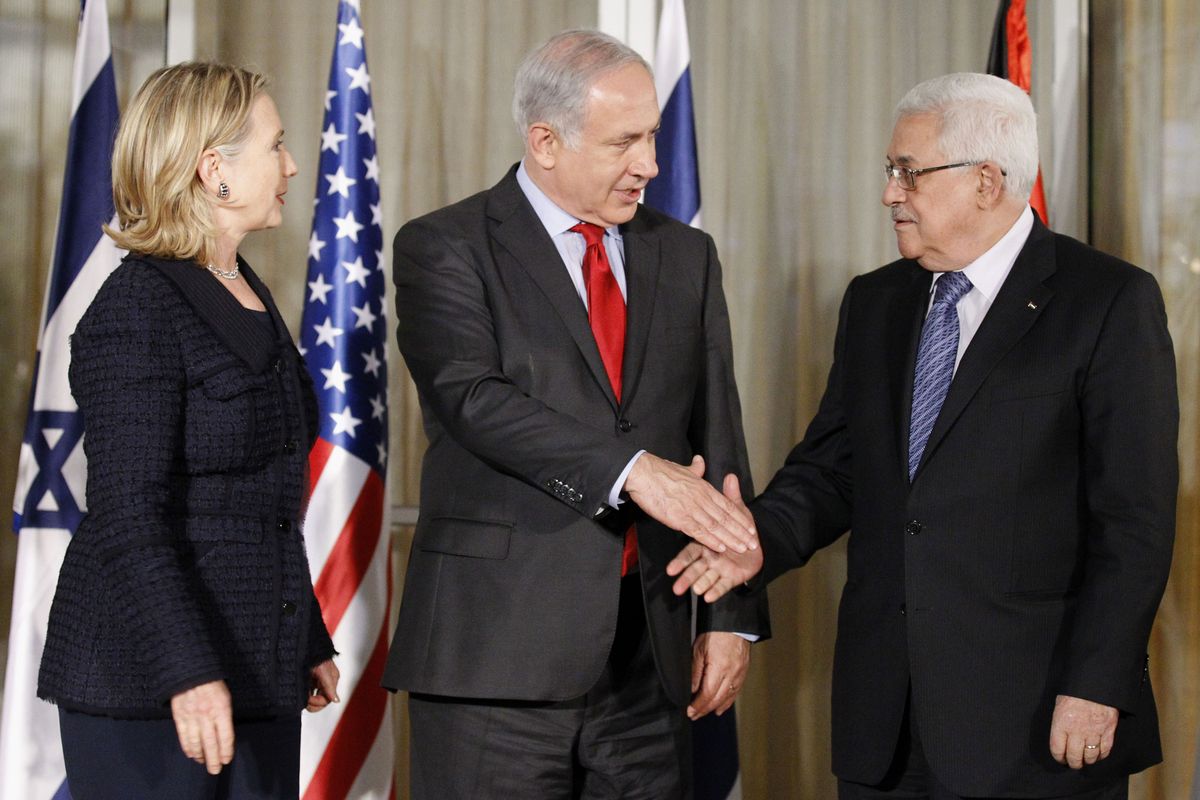 U.S. Secretary of State Hillary Rodham Clinton watches as Israeli Prime Minister Benjamin Netanyahu, center, shakes hands with Palestinian President Mahmoud Abbas at his residence in Jerusalem on Wednesday.  (Associated Press)