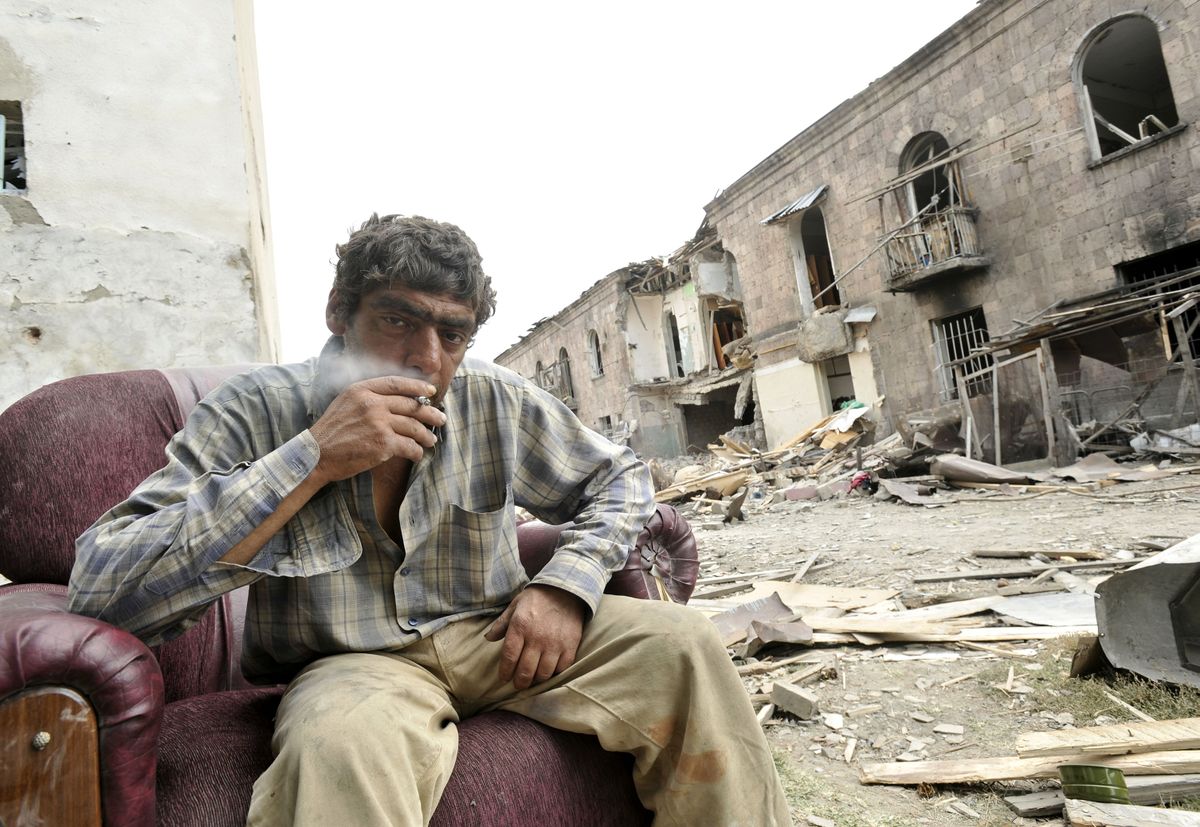 A man sits in an abandoned chair beside his destroyed apartment building in Gori, Georgia, where most of the residents have been evacuated.  (Associated Press / The Spokesman-Review)