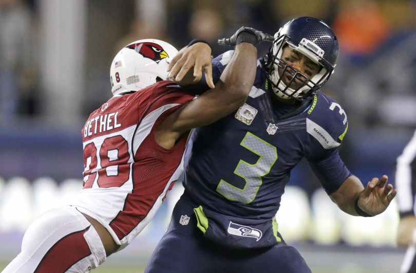 Seattle Seahawks quarterback Russell Wilson (3) is hit by Arizona Cardinals cornerback Justin Bethel just after getting a pass off. (Stephen Brashear / Fr159797 Ap)