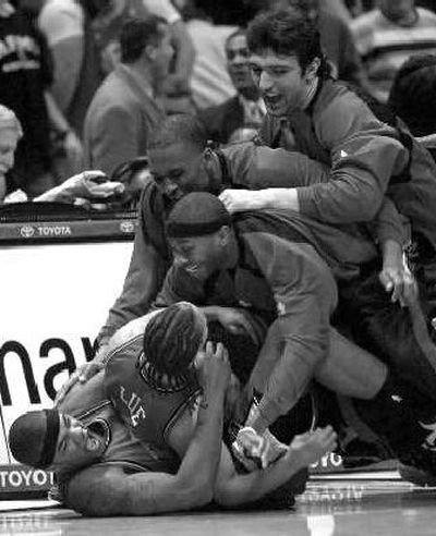 
Hawks tackle Tyrone Lue after game-winner.
 (Associated Press / The Spokesman-Review)