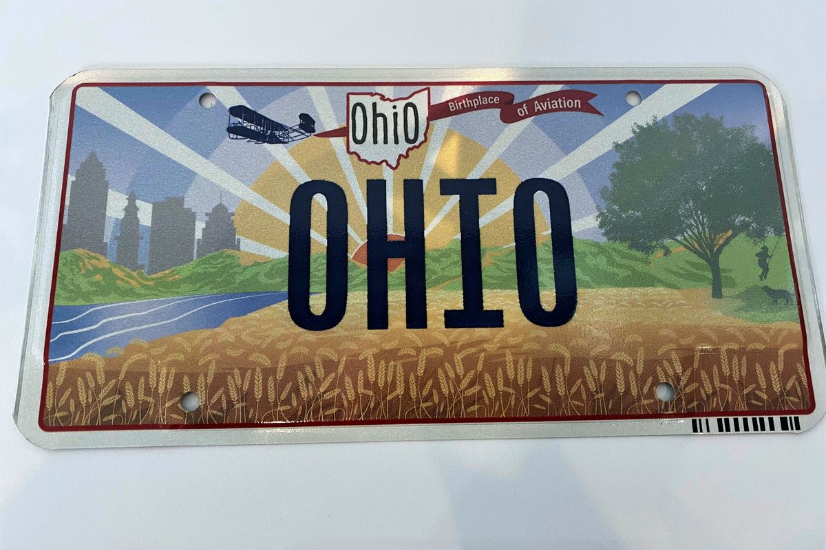 FILE - Ohio Gov. Mike DeWine on Thursday, Oct. 21, 2021, unveiled the new "Sunrise in Ohio" license plate in Columbus, Ohio. The backward Wright Flyer that was at the center of an embarrassing license plate mistake in Ohio last year flew through the approval process with little to no discussion, records show. The mistake was fixed immediately once it was discovered. The new “Sunrise in Ohio” plate became available to the public last week.  (Jessie Balmert)