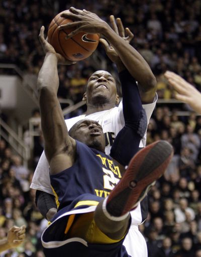 Purdue’s JaJuan Johnson, top, blocks the shot of West Virginia’s Darryl Bryant during No. 4 Purdue’s 77-62 home win.  (Associated Press)