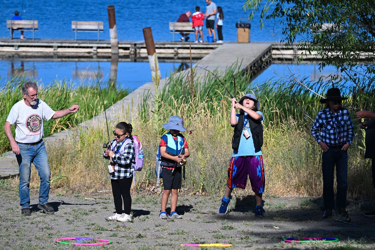 George Fisher, left, teaches Meniah McDonald, 6, James Natseway, 7, Teddy Natseway, 10, and Samuel Swank, 13, to cast a line during the Isaac Foundation Fish Pockets youth fishing event Saturday at Clear Lake. The gathering honored Brayden Bahme who died in an accident during phys ed class at Cheney High School in April 2023. (DAN PELLE/FOR THE SPOKESMAN-REVIEW)