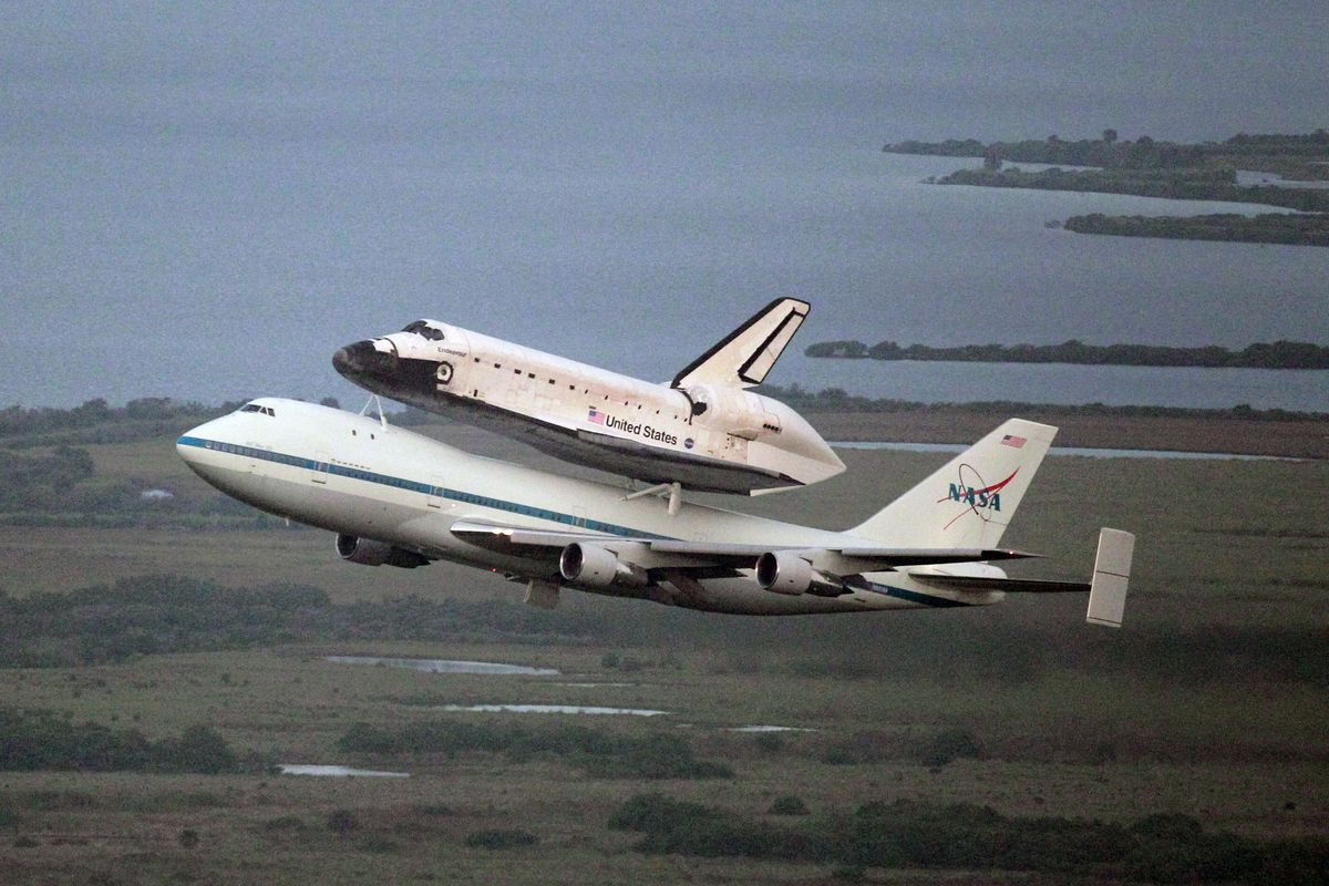 Space shuttle Endeavour, bolted atop a modified jumbo jet, makes its departure from the Kennedy Space Center, Wednesday, Sept. 19, 2012, in Cape Canaveral, Fla. Endeavour will make a stop in Houston before heading to the California Science Center in Los Angeles. (John Raoux / Associated Press)