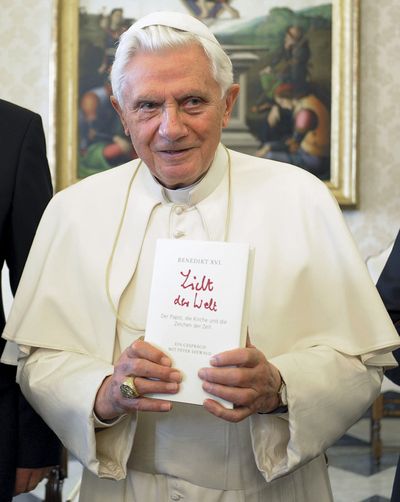 Pope Benedict XVI holds a copy of the book “Light of the World,” a series of Pope interviews with German journalist Peter Seewald.  (Associated Press)