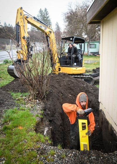 The Pinecroft Mobile Home Park (which has been under a boil water order since last summer) finally got the go ahead to install a new water system. Colville Construction’s Cody Baker, front and Dennis Barton, on the excavator, search for a four-inch water line next to the pump house, Tuesday, March 31, 2020, in Spokane Valley, Wash. (Dan Pelle / The Spokesman-Review)