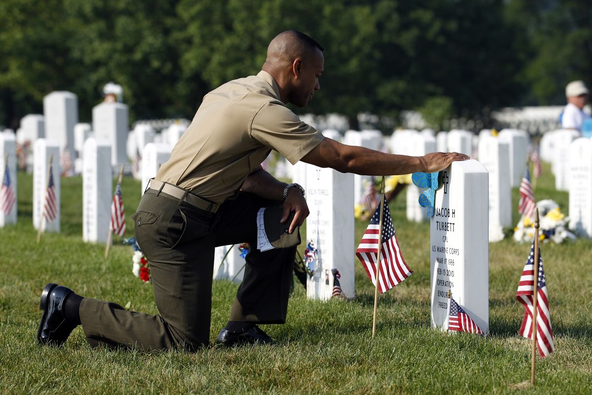 Marine Lt. Col. Cal Worth Jr. prays over the grave of his friend Jacob H. Turbett in Section 60 of Arlington National Cemetery on Monday. (Associated Press)