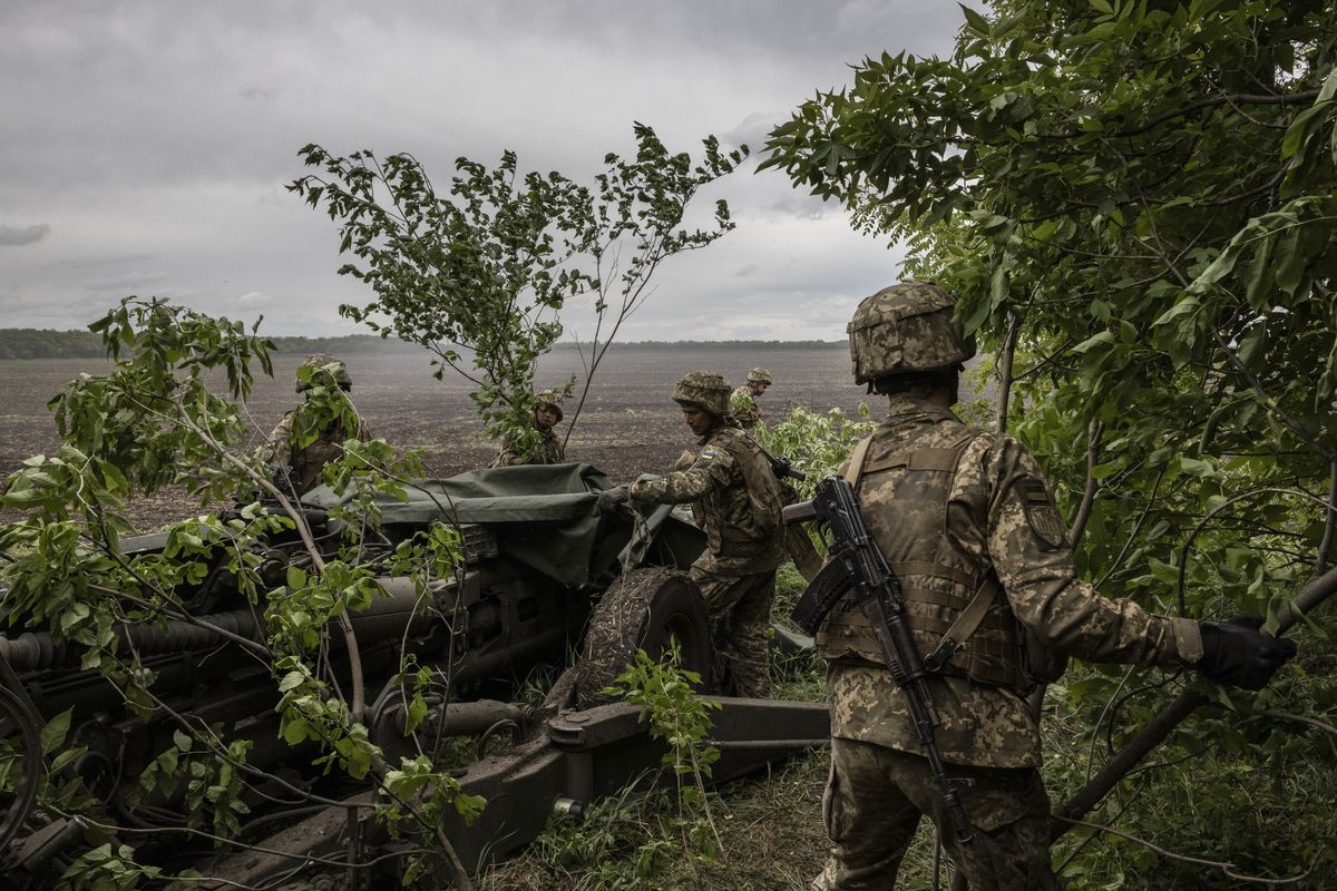 **EMBARGO: No electronic distribution, Web posting or street sales before MONDAY 03:01 A.M. ET JUNE 19, 2023. No exceptions for any reasons. EMBARGO set by source.** FILE -- Ukrainian soldiers camouflage an American-made howitzer near Donetsk, Ukraine, May 22, 2022. Ukraine has paid contractors hundreds of millions of dollars for weapons that have not been delivered, and some of the much-publicized arms donated by its allies have been so decrepit they were deemed fit only to be cannibalized for spare parts. (Ivor Prickett/The New York Times)