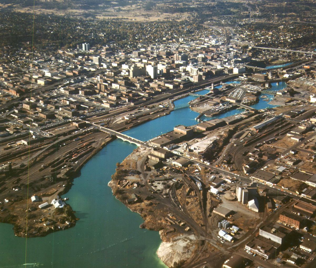 1960s - This aerial from before Expo 74 shows the downtown Spokane River at its most industrialized, dedicated to railyards, factories and warehouses. In the wake of the world’s fair, industrial uses were replaced with Riverfront Park, hotels, restaurants, businesses and the University District where the region’s universities come together in a high tech environment. (SPOKESMAN-REVIEW PHOTO ARCHIVE / SR)