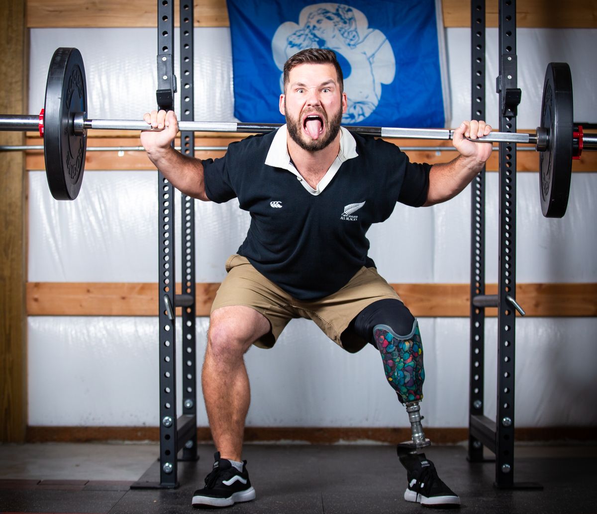 Jacob Hansen, architect of the Kootenai 7’s tournament, poses for a photo in the squat rack of his home gym on Wednesday in Newman Lake. Hansen had been planning the tournament since February, and it picked up traction that resulted in promotions from USA Rugby and registrations from 10 teams across five states for Saturday’s tournament in Post Falls. As the pandemic receded, the idea sprung forth as a way for Hansen to give back to the rugby community that supported him after a severe injury.  (Libby Kamrowski/ THE SPOKESMAN-REVIEW)