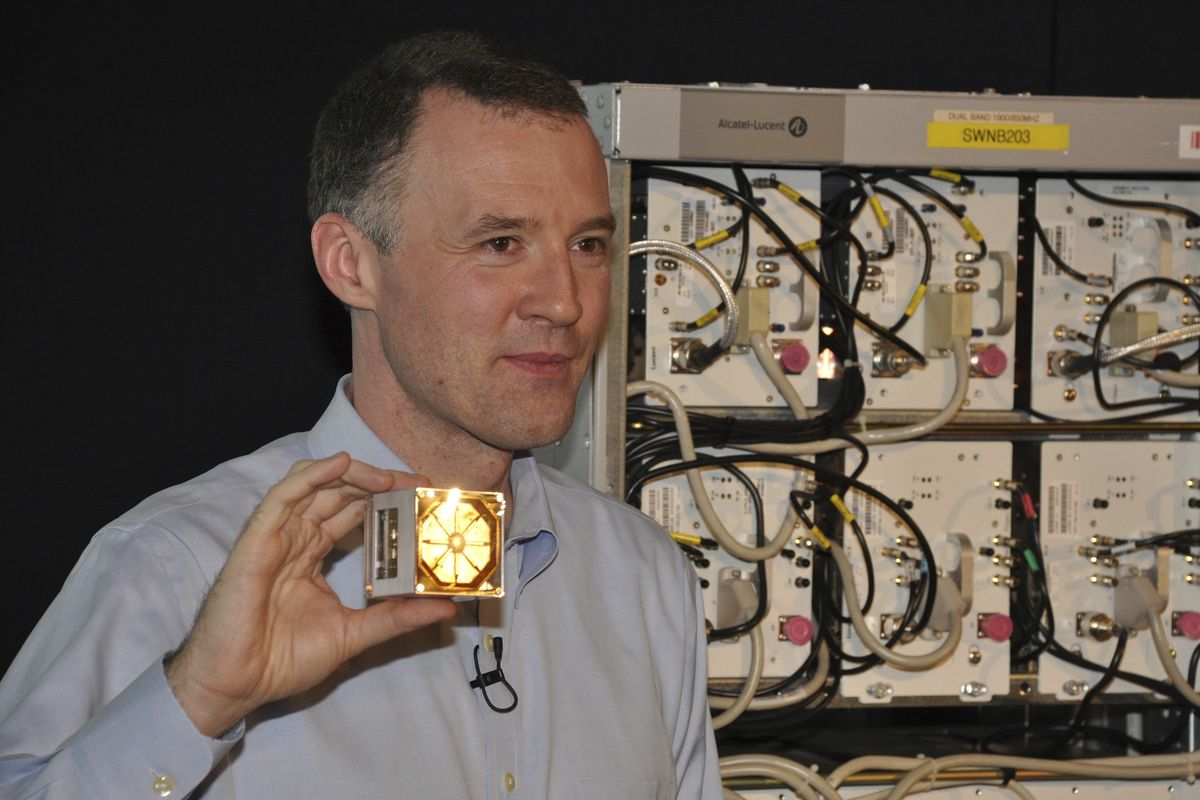 Wim Sweldens, the president Alcatel-Lucent’s wireless division is seen holding a lightRadio cube. The cube integrates much of the regular workings of a conventional cell phone base station, seen behind Sweldens. (Associated Press)