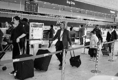 
JetBlue passengers check in at JFK airport on Tuesday with operations and flight schedules resuming as the company announced that it was rolling out a customer bill of rights that promises vouchers to fliers who experience delays. JetBlue hopes the move will win back passengers. 
 (Associated Press / The Spokesman-Review)