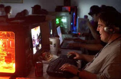 
Brian Habets of Spokane laughs as he triumphs in the game of Car Ball at the Spokane Local Area Network party at the Budget Inn on Saturday afternoon. Habets' computer was illuminated by a red neon light. 
 (Holly Pickett / The Spokesman-Review)