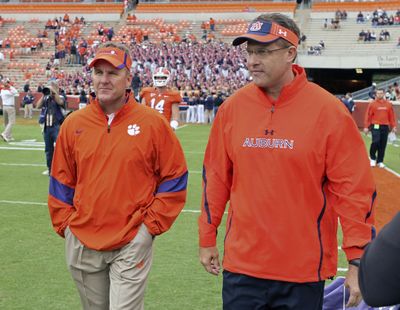 In this Sept. 17, 2011 photo, then-offensive coordinators Chad Morris, left, of Clemson, and Gus Malzahn, right, of Auburn, walk together on the field at Memorial Stadium before an NCAA college football game, in Clemson, S.C. Morris is now the head coach at Arkansas. Malzahn is the head coach at Auburn. The two chat each week – except when they play each other. (Mark Crammer / Independent-Mail via AP)