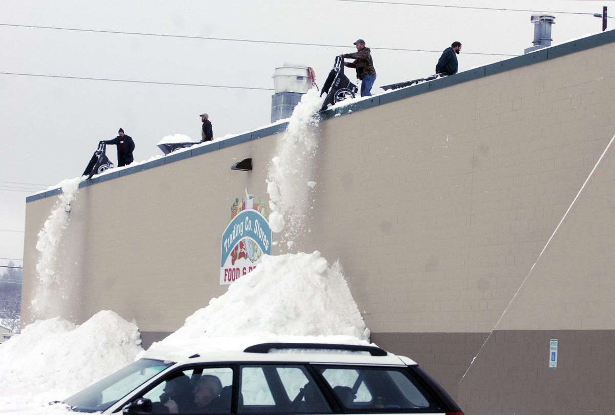 A large crew  with wheelbarrows remove snow from the roof of the Trading Co. Store at 13014 E. Sprague Ave. Monday. Many businesses are concerned with the record snowloads on their roofs.  (J. BART RAYNIAK / The Spokesman-Review)