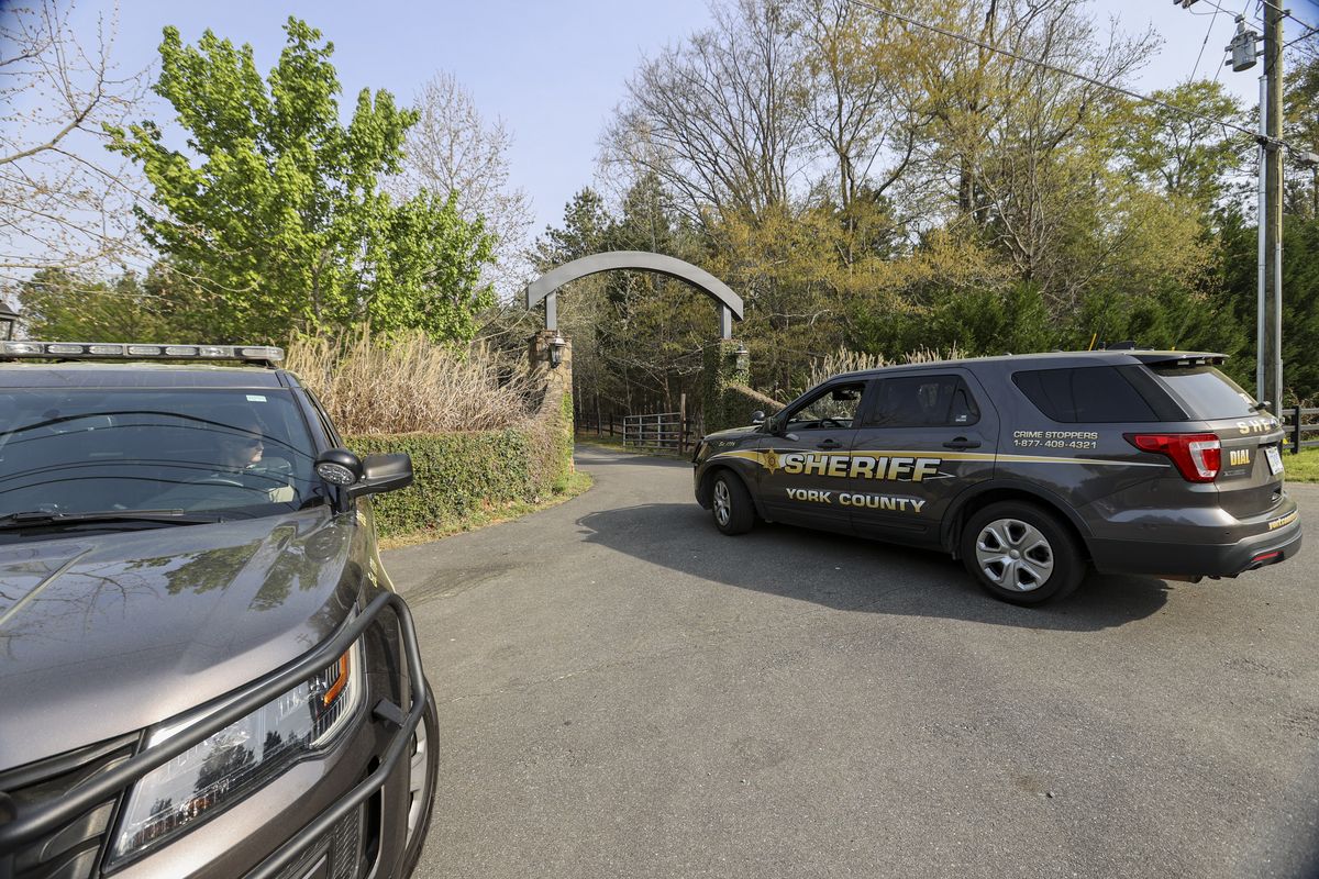 A York County sheriff vehicle drives onto the property where multiple people, including a prominent doctor, were fatally shot a day earlier, Thursday, April 8, 2021, in Rock Hill, S.C. A source briefed on the mass killing said the gunman was former NFL player Phillip Adams, who shot himself to death early Thursday.  (Nell Redmond/Associated Press)