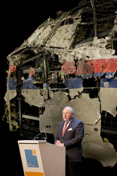 Tjibbe Joustra, head of the Dutch Safety Board, presents the boards final report into what caused Malaysia Airlines Flight 17, seen reconstructed rear, to break up high over Eastern Ukraine last year, killing all 298 people on board, during a press conference in Gilze-Rijen, central Netherlands, Tuesday, Oct. 13, 2015. (Peter Dejong / Associated Press)