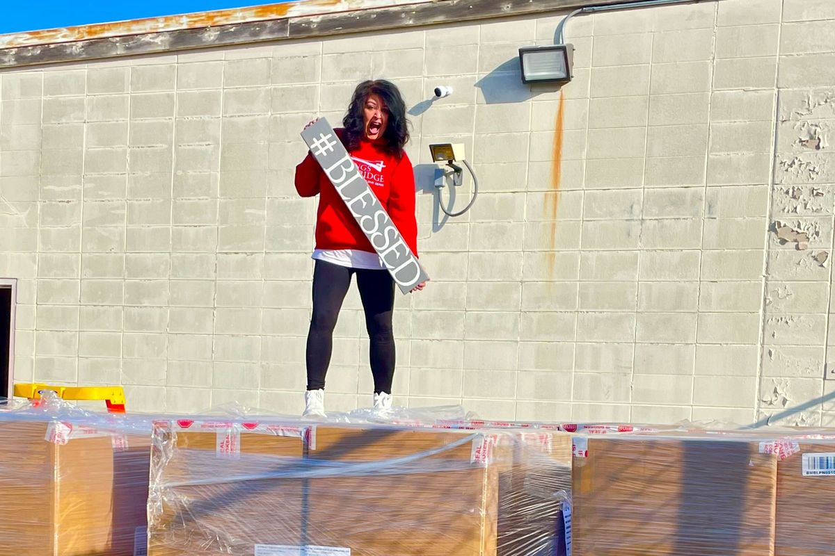 Jessica Kovac stands atop a pallet of 25,000 pairs of socks donated to her organization, Blessings and Beyond.  (Courtesy of Blessings and Beyond)