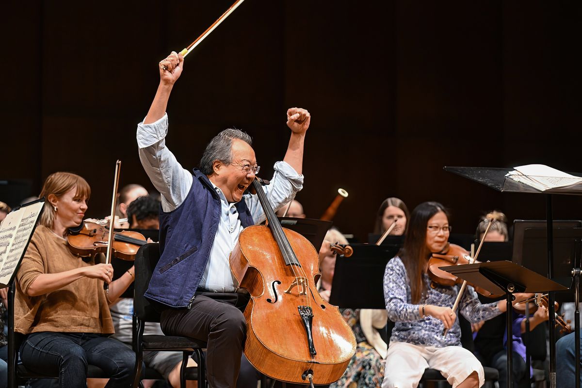 Renowned cellist Yo-Yo Ma celebrates his performance under the direction of Spokane Symphony Conductor James Lowe during a rehearsal Wednesday at the Martin Woldson Theater at the Fox. Violinist Amanda Howard-Phillips is at left and violist Jeannette Wee-Yang is at right.  (DAN PELLE/THE SPOKESMAN-REVIEW)