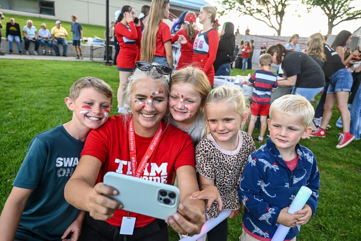 Riverside Assistant Principal Amy Owens snaps a picture with Remi Mace, Hadlee Burns, Dylanee Burns and Rhett Burns during the Rise as One event for Elk fire victims, Friday, Sept. 1, 2023, at Riverside High School.  (DAN PELLE/THE SPOKESMAN-REVIEW)