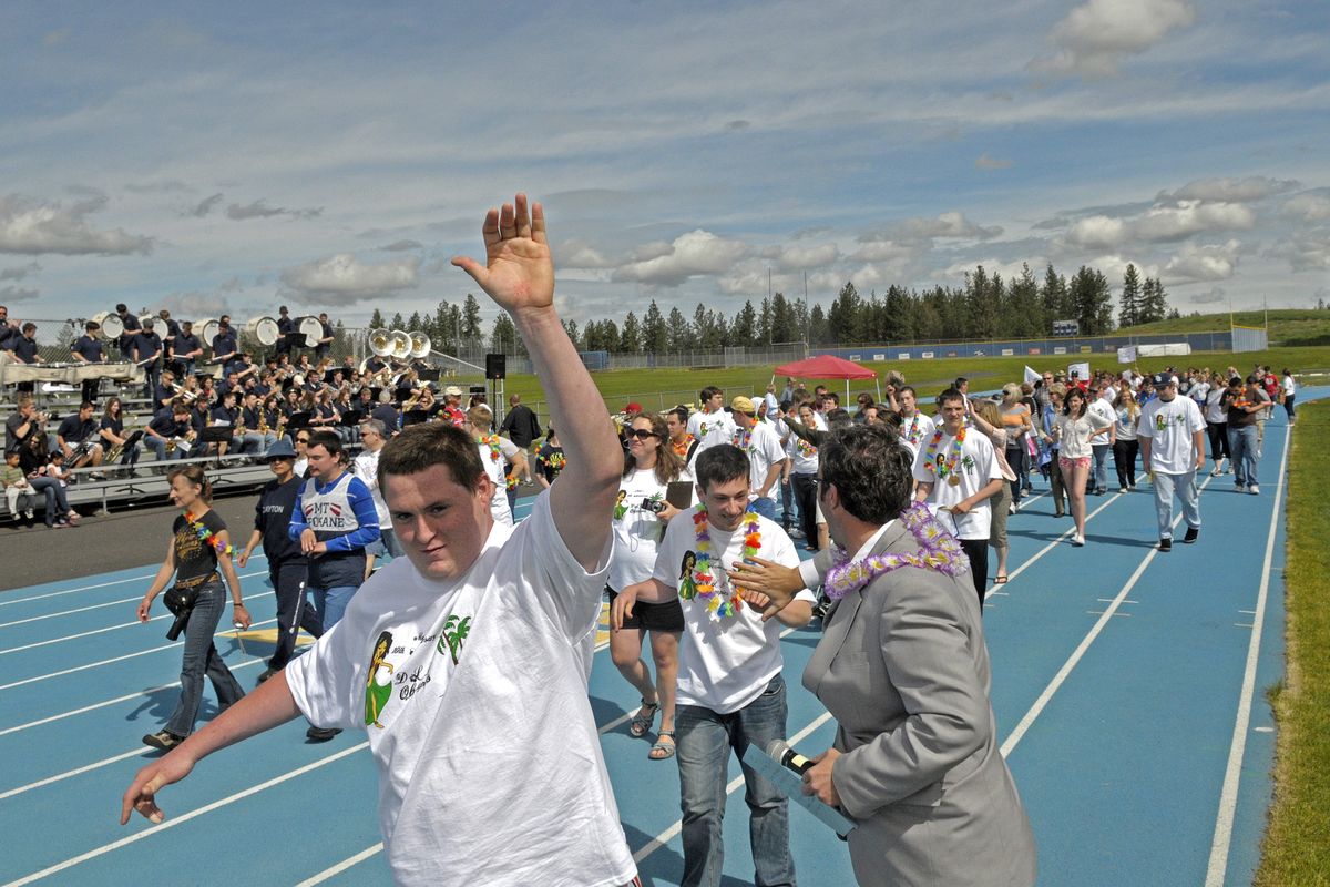 Mead High School Principal Ken Russell, right, high-fives marchers in the opening parade at the Mead High School track for the Developmental Learning Center’s Olympics event May 25. (CHRISTOPHER ANDERSON photos)