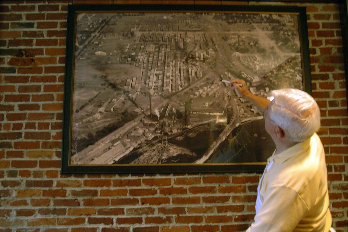 Jack Stockton points out an interesting feature of a historical photo showing the Gonzaga neighborhood where Jack and Dans Bar and Grille is located Thursday Sept. 29, 2005. During an expansion into the former drugstore next door they saved and restored the brick walls where the photo hangs. (Christopher Anderson / The Spokesman-Review)