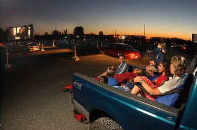 
Movie fans enjoy a night at the Valley 6 Drive-In in Auburn, Wash., in the back of their pick-up truck. Drive-ins are entertainment relics, steadily losing customers to indoor theaters with earsplitting sound systems and cushy stadium seats. They also are gold mines for the future. 
 (Associated Press / The Spokesman-Review)
