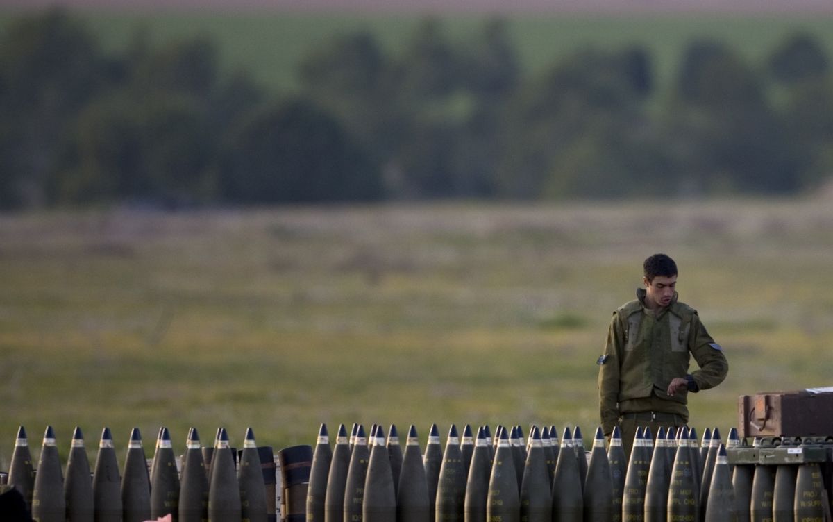 An Israeli soldier stands next to artillery shells at a staging area on the Israel side of the Gaza border. Associated Press photos (Associated Press photos / The Spokesman-Review)