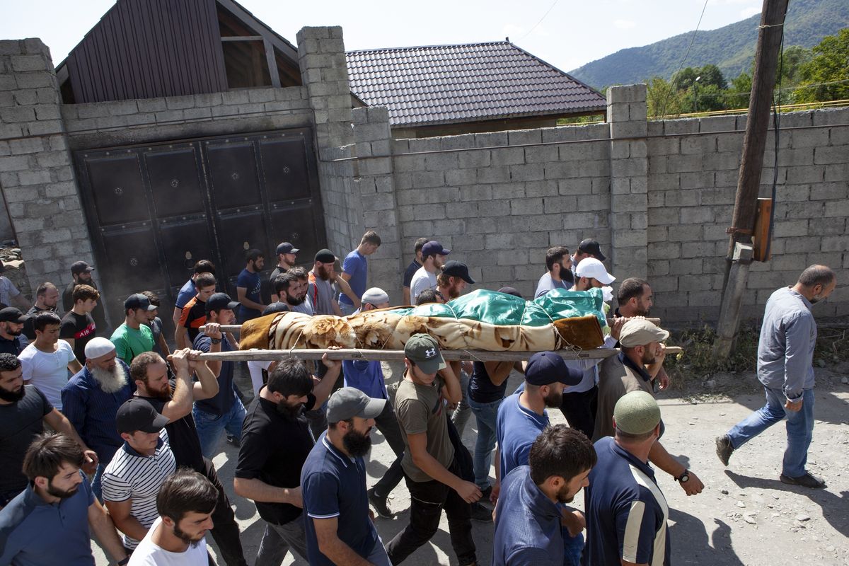 FILE - People carry the body of the victim who has been identified as Zelimkhan Khangoshvili, a Georgian Muslim during the funeral in Duisi village, the Pankisi Gorge valley, in Georgia, Aug. 29, 2019. A Berlin court will deliver its verdict Wednesday, Dec. 15, 2021 in the trial of a Russian man accused of a killing in the German capital two years ago that prosecutors say was ordered by Russia. The slaying of Zelimkhan “Tornike” Khangoshvili, a 40-year-old Georgian citizen of Chechen ethnicity, sparked outrage in Germany and prompted the government to expel two Russian diplomats — and a reciprocal response by Moscow.  (Zurab Tsertsvadze)