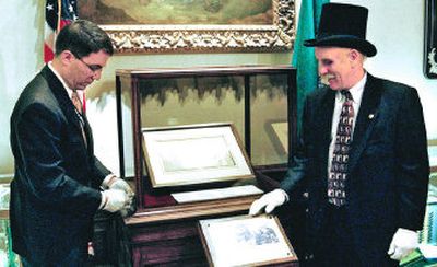 
Patrick McDonald locks a display case holding a  letter from George Washington as state archivist Jerry Handfield watches on Thursday.
 (Richard Roesler / The Spokesman-Review)