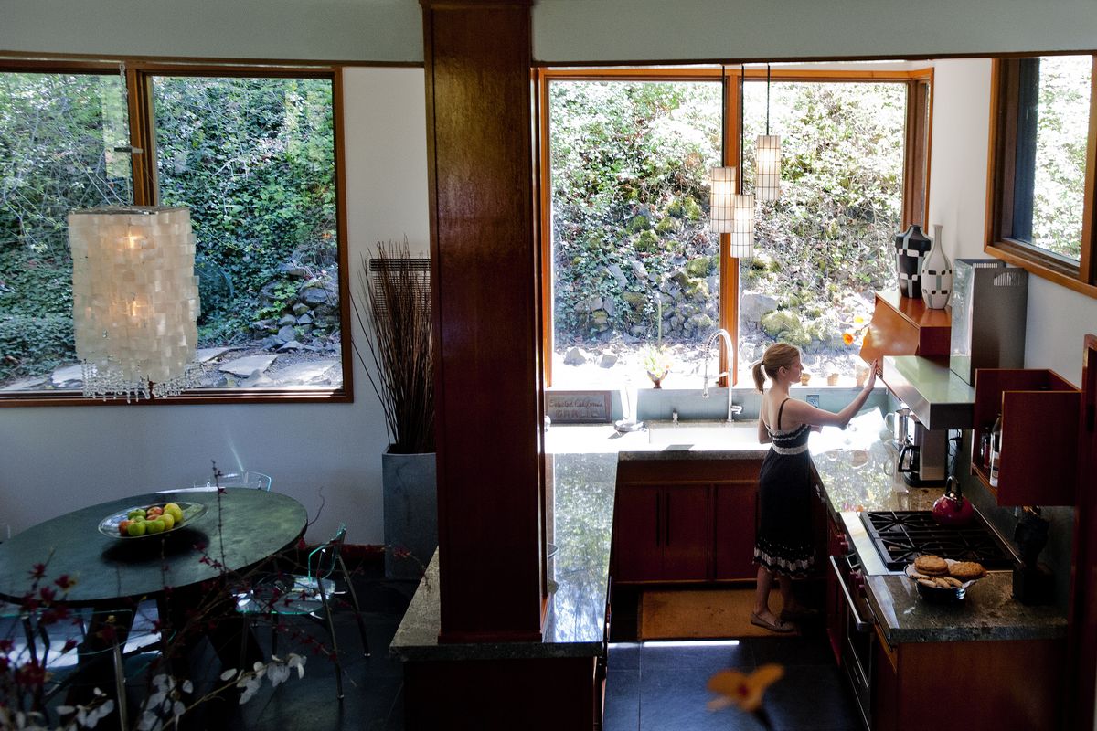 Kate Odorizzi works in the kitchen of the South Hill home she shares with Pat Smith on Thursday in Spokane. The early 1950s home designed by architect Warren C. Heylman will be part of the Mother’s Day Home Tour. (PHOTOS BY TYLER TJOMSLAND)