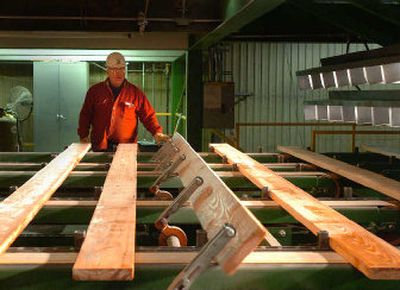 
Hank Coleman, a grader at the Riley Creek Lumber mill in Chilco, checks boards  as they move past his station. He looks  for defects and marks the boards accordingly. U.S. mills know they have to produce a better quality board than Canadian lumber mills to compete with the flood of timber from Canada, where stumpage costs are much lower. 
 (Photos by Jesse Tinsley / The Spokesman-Review)